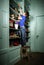 Freckled red-haired little boy searching book on bookcase