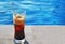 Freddo espresso coffee in front of a pool - cold coffee - summer vacation concept