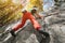 A free aged male climber hangs on a rock wall in a forest in the mountains. Mature Sports Concept