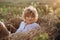 Free beautiful girl with curly hair in a field with wheat at sunset. Female power and independence. Soft selective focus