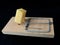 Free cheese in a mousetrap on a black background. Wooden trap with bait and mechanism for rats and mice