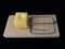 Free cheese in a mousetrap on a black background. Wooden trap with bait and mechanism for rats and mice