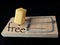 Free cheese in a mousetrap on a black background. Wooden trap with bait and mechanism for rats and mice