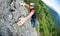 A free-climber reaches the top of a rocky wall. Concept: courage