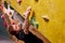 Free climber young man climbing on practical wall indoor, bouldering alone