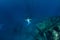 Free diver in the depth make ring bubbles near shipwreck