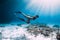 Free diver glides over sandy sea with fins. Freediving in blue sea