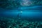 Free diver swim in ocean, underwater photo with sunlight