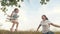 The free family is having fun in the park. mother shakes her healthy little daughter on a swing under a tree in the sun