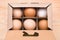Free grazing of hens. Chicken products in a cardboard box. Exclusive agricultural method. Cardboard box with brown eggs
