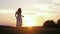 Free Happy Caucasian Woman In White Dress Runs Across Field To Meet The Sunset