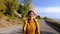 Free Happy Young Hiker Woman in yellow coat enjoying calm sunny day in the nature breathing fresh air