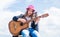 Free music content. Teenage musician playing guitar. Portrait of little kid playing guitar on sky background. summer