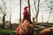 Free range breeding - Portrait of illuminated single hen New Hampshire hen standing and feeding in front of the fence on green