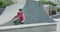 Free runner doing extreme flips on skateboard track and sits on bench to think