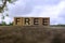 Free text on wooden cube block on top of stone with blurred sky background