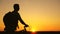 A free traveler travels with a bicycle at sunset. Hiker healthy guy goes with a bicycle around field, enjoying nature