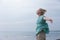 Free woman enjoying windy weather on beach on overcast day