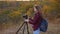 Free woman traveler with camera takes beautiful nature photos. A young independent tourist photographer photographing a