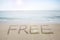 Free word handwritten in sand on sunny beach