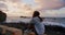 Free young joyful woman on wild beach, breathing deeply and enjoying fresh air, looking on beautiful seaside waves