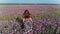 Free young woman in dress walking on the purple flower field