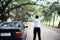 Freedom African man wearing a white shirt and sunglasses standing with car