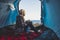 Freedom and alternative tiny house or wild independent vacation concept with blonde girl sitting on the tent and looking the sea