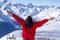 Freedom concept, girl looks at snowy mountains on blue sky background