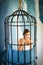 Freedom of cute girl in cage. got something on her mind. woman in iron cage. fashion slave in captivity of beauty