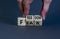 Freedom from fear symbol. Businessman turns wooden cubes and changes the word `fear` to `freedom`. Beautiful grey background,