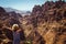 Freedom female wanderlust standing with raised hands enjoying majestic mountain landscape. Hipster young girl explore world. Summe