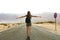 Freedom flying woman in free happiness bliss in empty asphalt desert road. Happy female traveler backpacker enjoying silence