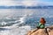 Freedom happy redhead woman sitting in meditation enjoying view of a frozen lake Baikal surface. Winter tourism concept