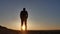 Freedom. Man stands on a cliff sunset silhouette hand lifestyle in the sides