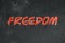 Freedom text graffiti on grunge wall