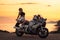 Freedom and travel. Sexy caucasian young woman poses sitting on motorcycle. Golden sunset and motorbike on the