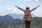 Freedom traveler woman standing with raised arms and enjoying a beautiful nature