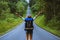 Freedom traveler woman standing with raised arms and enjoying a beautiful nature On a country road. woman with backpack travel In