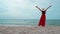 Freedom woman walking with arms raised on sea beach with wind blow