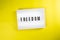 Freedom word on lightbox on yellow background isolated flat lay