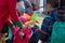 A freelance clown creating balloon animals and different shapes at outdoor festival in city center.