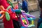 A freelance clown creating balloon animals and different shapes at outdoor festival in city center.