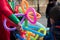 A freelance clown creating balloon animals and different shapes at outdoor festival in city center.