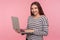 Freelance job, online study. Portrait of happy friendly young woman in striped sweatshirt holding laptop and smiling to camera