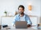 Freelance Lifestyle. Portrait Of Smiling Eastern Guy Sitting At Desk With Laptop