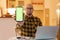 Freelance and online communication. Portrait of smiling Caucasian bald bearded young man shows green screen of cellphone