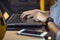 Freelance woman hand using computer laptop keyboard mousepad with mobile phone on table.