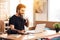 Freelancer bearded man drinking coffee at laptop sitting at desk.