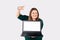 Freelancer. Caucasian smiling woman holds a laptop, pointing at the mock up screen with index finger. Plus size model